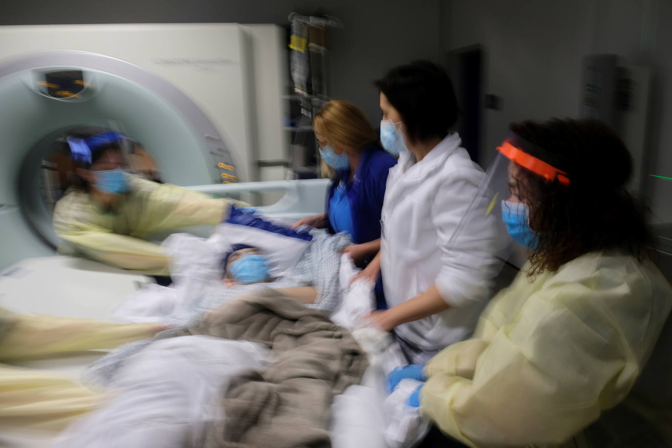 Enfermeras y radiógrafos levantan a Rebecca de un escáner CT.