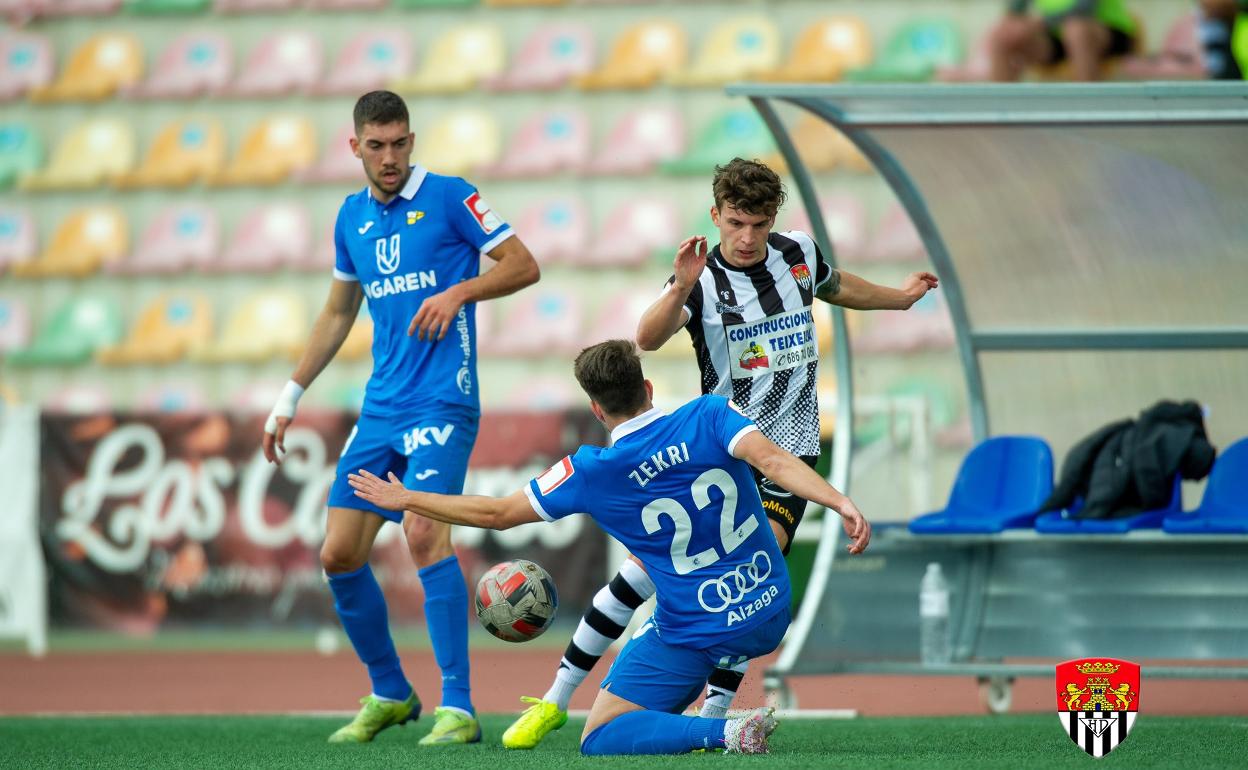 Zekri trata de robar un balón desde el suelo 