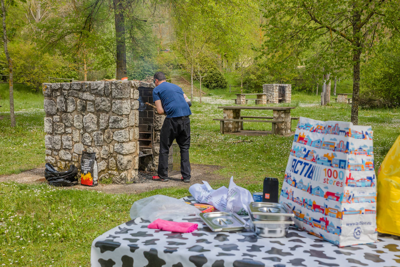 Bajo la ermita de la Virgen de la Peña, en el merendero, en una de las barbacoas frías durante meses, Jon se dispone a encender la brasa para asar panceta, chorizo y morcilla.