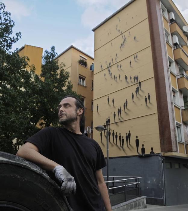 Suso33 posa ante un muro en Bilbao en el que plasmó sus 'Presencias', seña de identidad junto a su famosa 'plasta'.