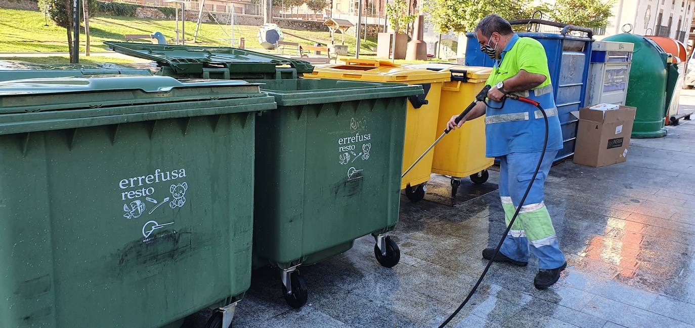 Un operario limpia una batería de contenedores de reciclaje en Llodio. 