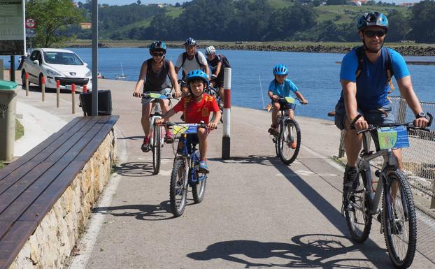 Una familia pedalea en el carril bici de Barros a Suances.