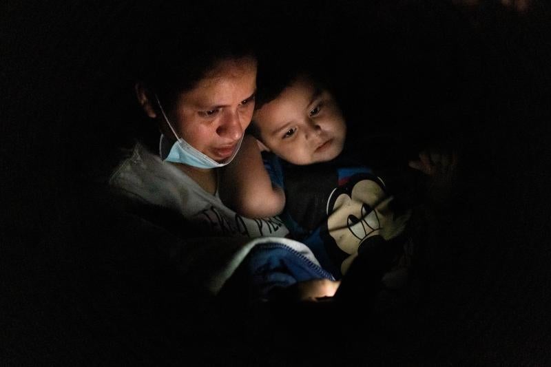 Anna ha llegado a la frontera con su hijo Carlo, de 22 meses desde Honduras. Usa el móvil para comunicarse con su familia y decirles que están bien.