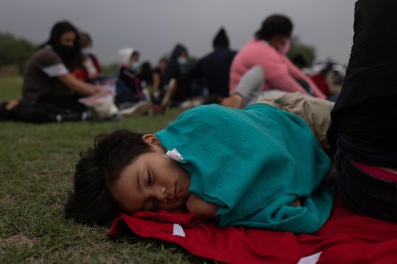 El viaje hasta la frontera es extenuante. Nathan, de seis años, ha caído rendido y es arropado por su madre mientras esperan a ser procesado.