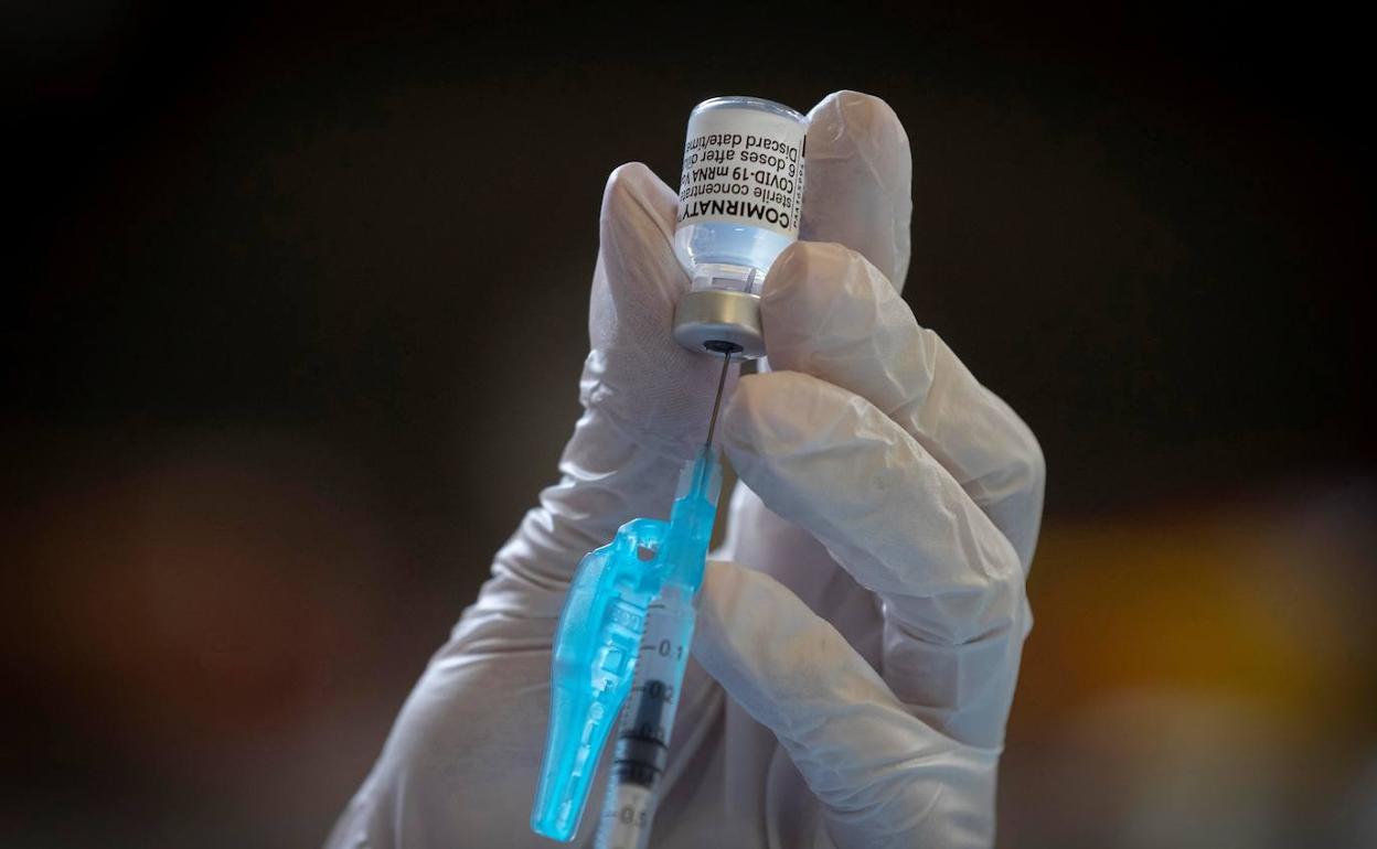 Extraen una dosis de un vial de Pfizer/BioNTech. 