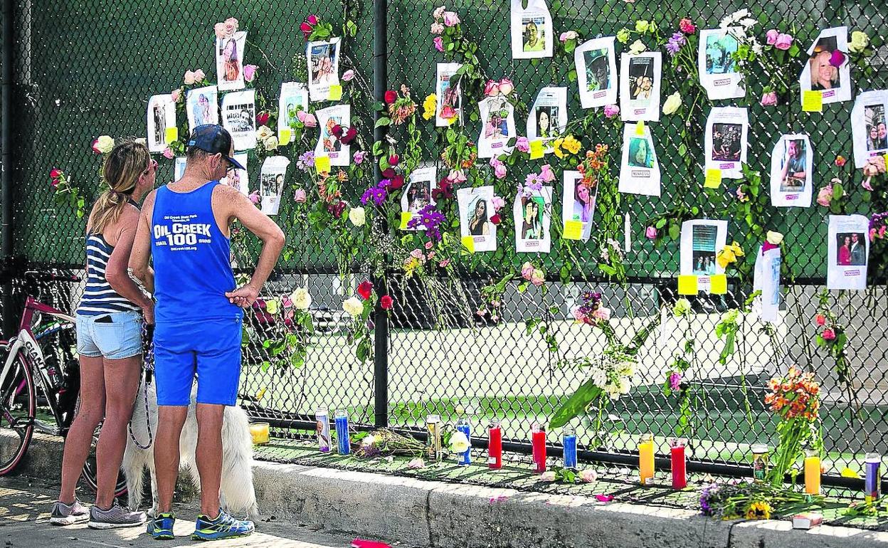 Allegados de los desaparecidos han colocado sus fotos en una valla, donde han depositado velas y flores en su honor.