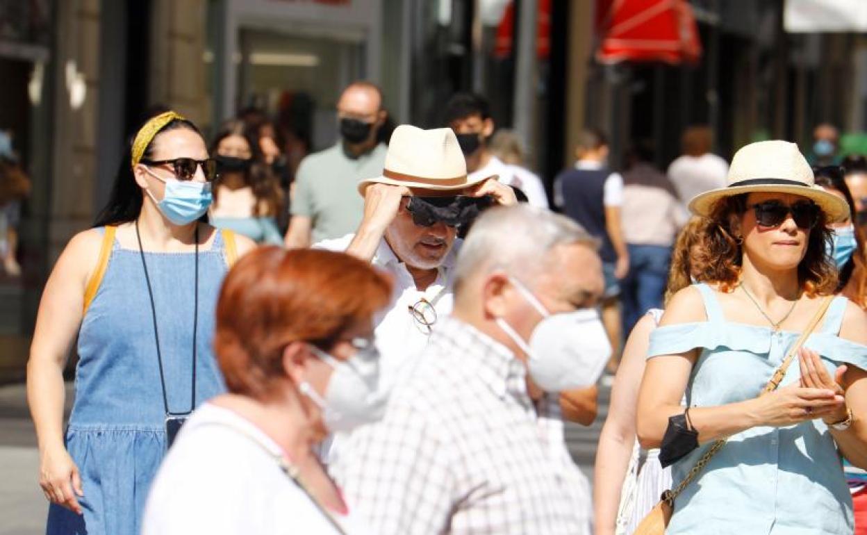 Varias personas con y sin mascarilla pasean por el centro de Córdoba.