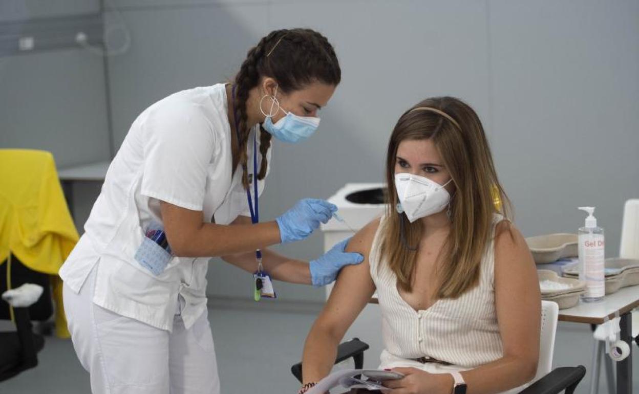 Una joven recibe una vacuna en el hospital Isabel Zendal de Madrid. 