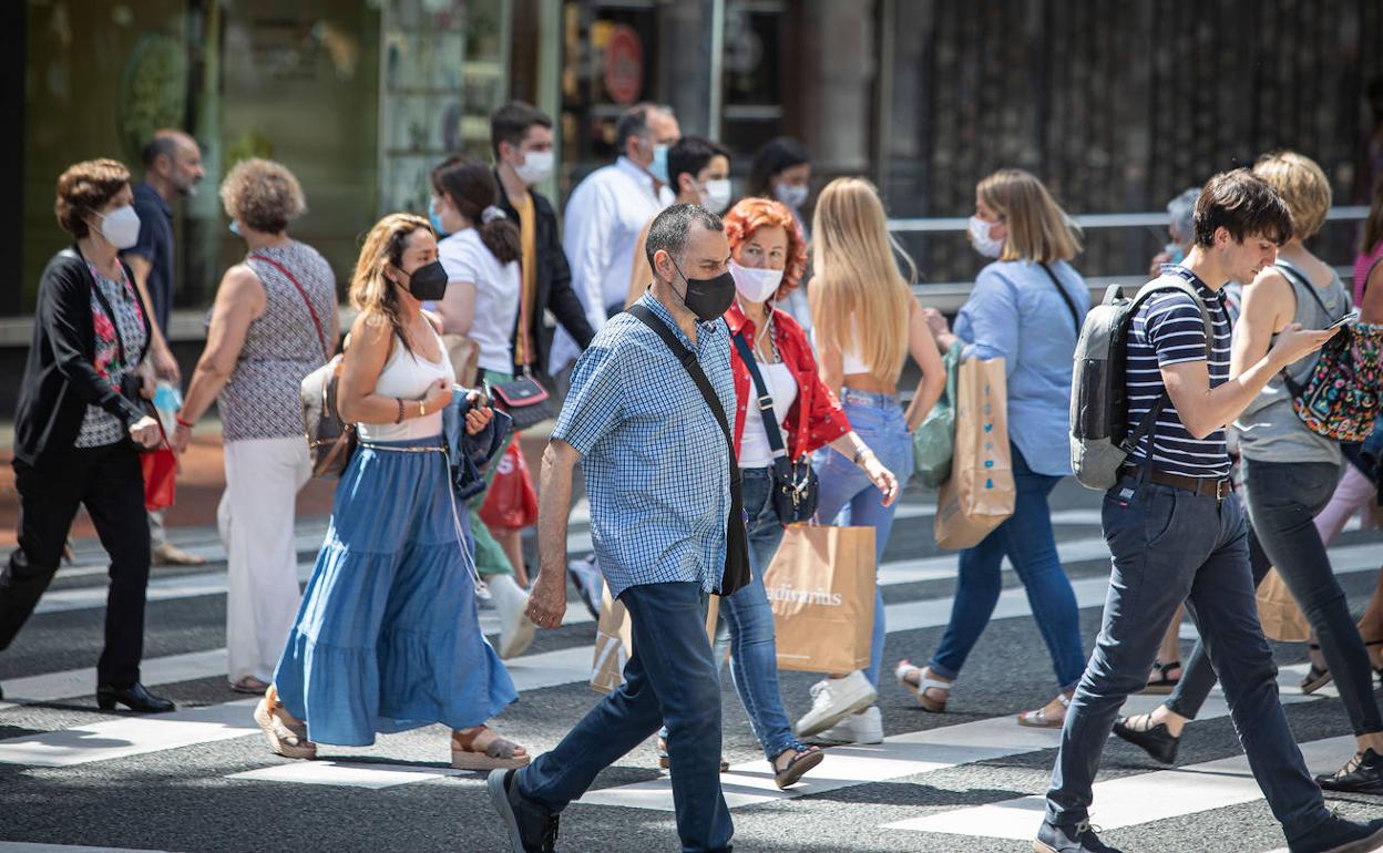 Varias personas cruzan por un paso de peatones en Bilbao. 