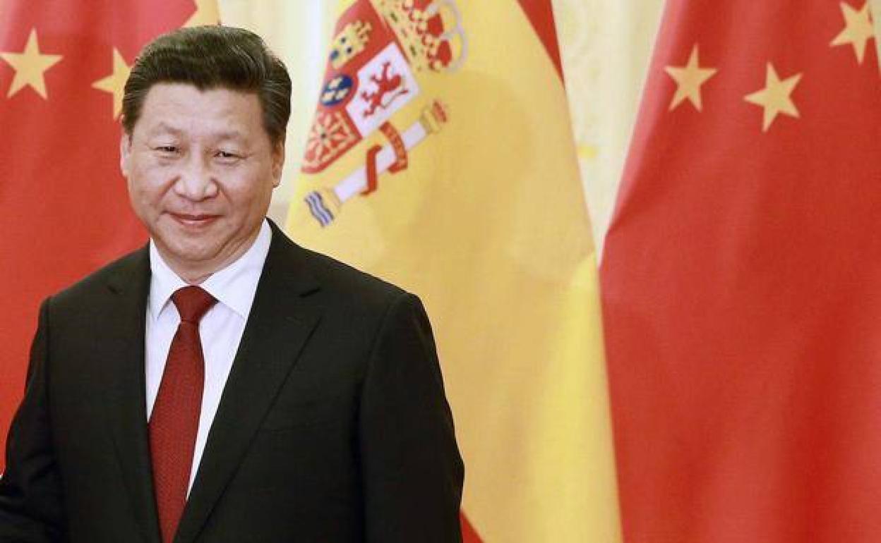 El presidente chino, Xi Jinping, con una bandera de España al fondo. 