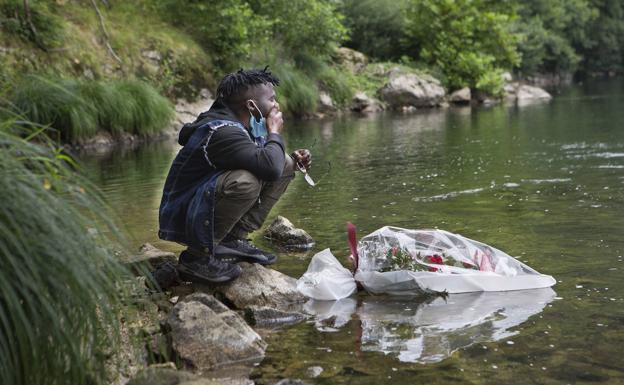 Mohame Lamine Camara, tío de Abdoulaye Koulibaly, llora tras dejar un ramo de flores en el lugar en el que se ahogó su sobrino.