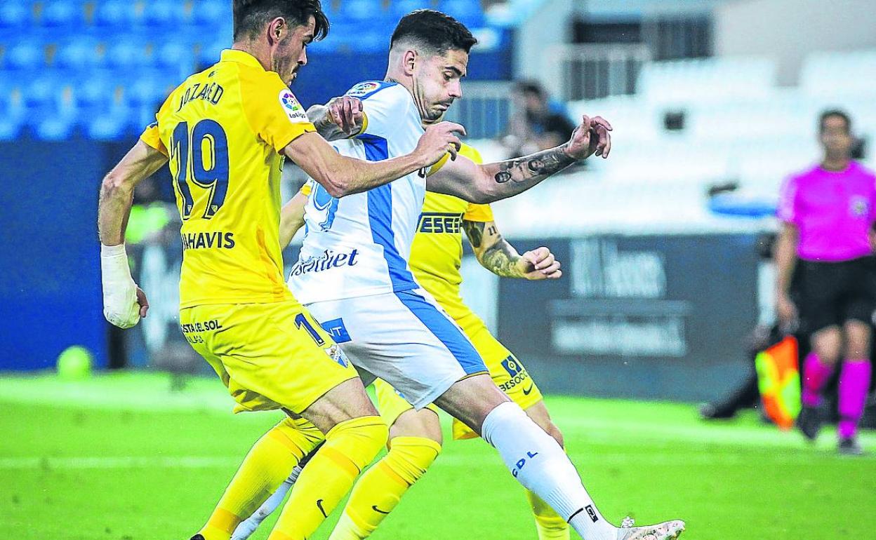 Miguel de la Fuente (Leganés) protege el balón ante la presión de Jozabed (Málaga). 