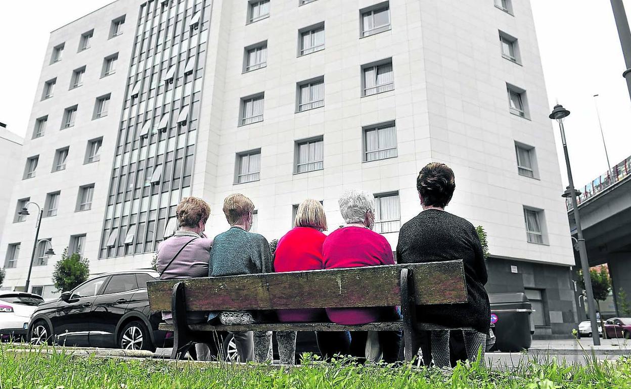 Cinco mujeres conversan en un banco frente a una residencia de Bilbao. 