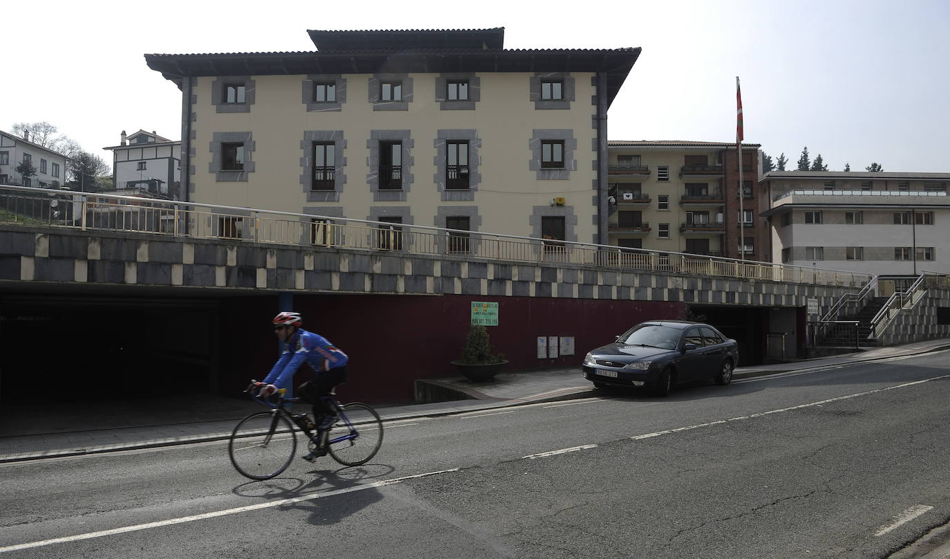 Un ciclista pasa frente al Ayuntamiento de Alonsotegi.