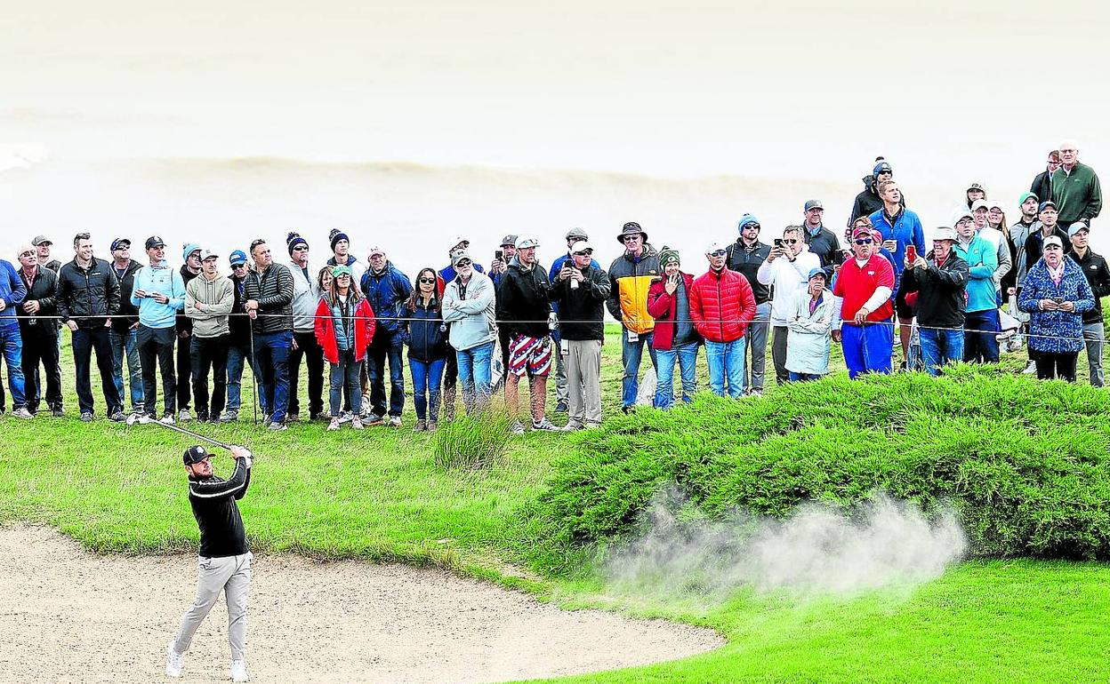 El inglés Tyrrel Hatton saca una bola del bunker en la ronda de prácticas de Whistling Straits, junto al lago Michigan. 