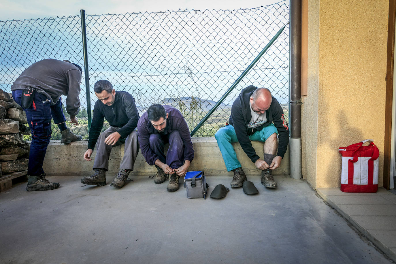 Los temporeros se calzan las botas antes de embarrarse en la viña