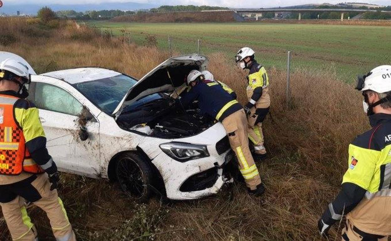 Los bomberos de la Diputación comprueban el estado del vehículo accidentado esta mañana en la AP-1 en Armiñón.