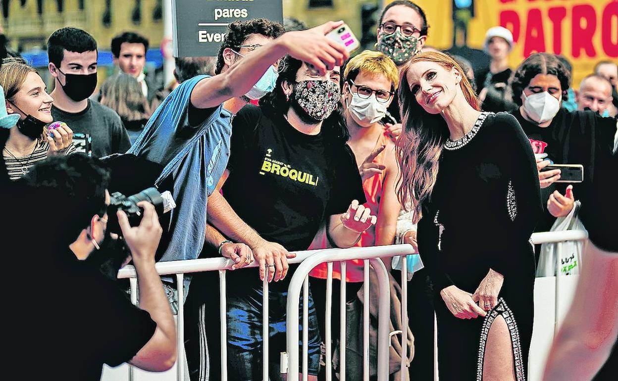Jessica Chastain rompe el férreo sistema de seguridad que impide acercarse a la alfombra roja y se fotografía con unos fans. 