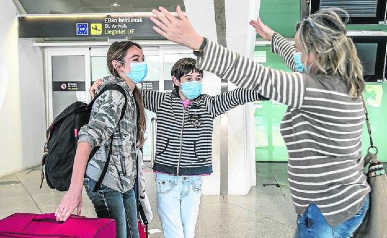 Tres personas se abrazan en la terminal cuando todavía podían acceder acompañantes. 