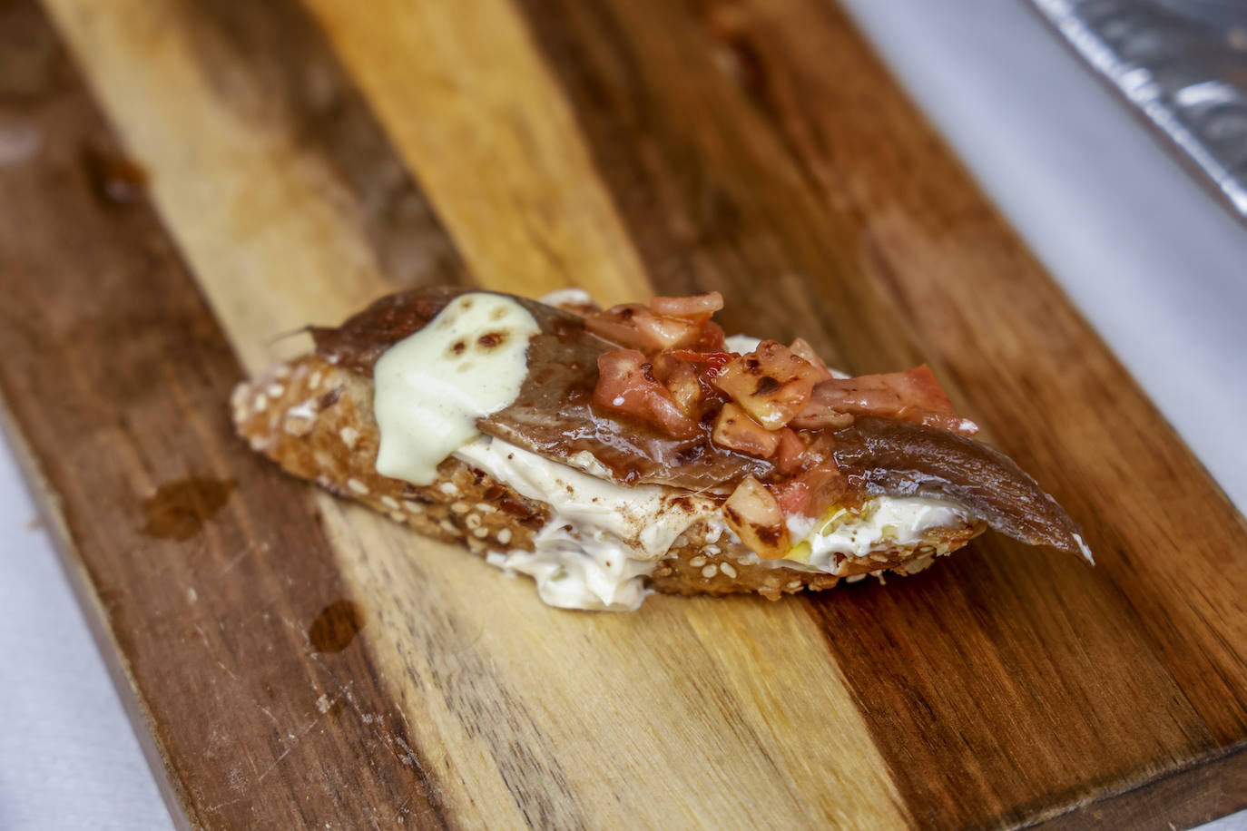 Tosta de anchoa marinada en soja y manzanilla con tártar de alcaparras y tomate concassé y cacao espolvoreado. El pintxo del bar Dólar.