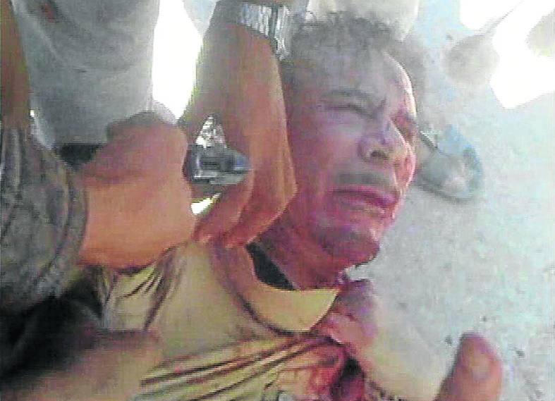 El dictador es apuntado en la cabeza tras su detención. 