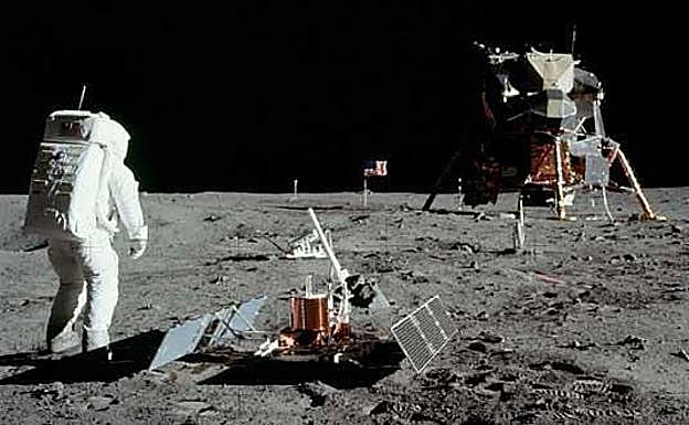 Buzz Aldrin, junto a un sismómetro, con el 'Aguila' y la bandera estadounisense al fondo.