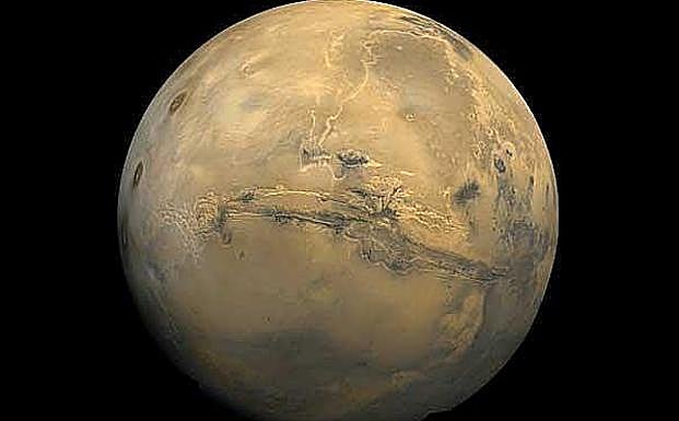 Valles Marineris aparece en esta visión de Marte como una gigantesca herida. Los tres puntos marrones de la izquierda son los montes de Tharsis, tres grandes volcanes.