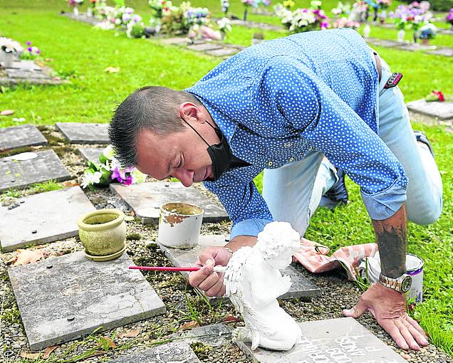 Con amor. Jonatan Freijamil pìnta de blanco un ángel que colocó sobre el nicho de su hermana fallecida.