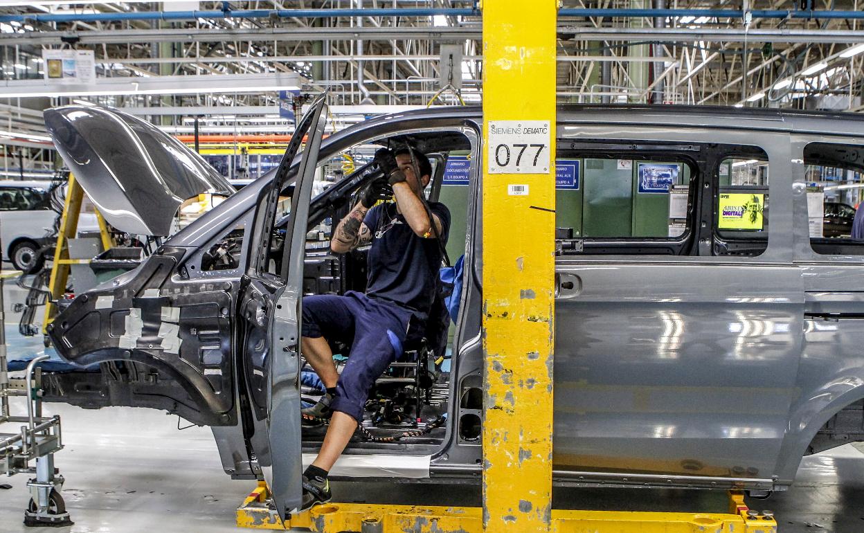 Un trabajador de Mercedes ajusta piezas en una furgoneta, en la cadena de producción de la planta de Vitoria.