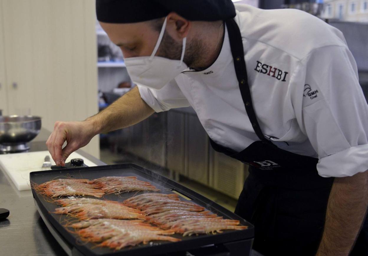 Un cocinero de la Escuela de Hostelería de Bilbao pasa por la plancha las gambas. 