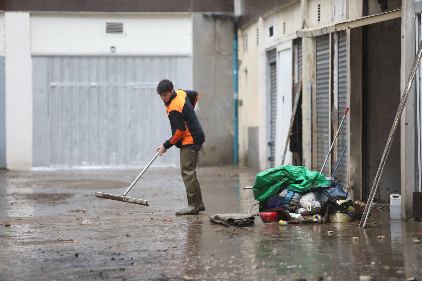 Propietarios limpian las lonjas afectadas por la subida del río en Basauri.