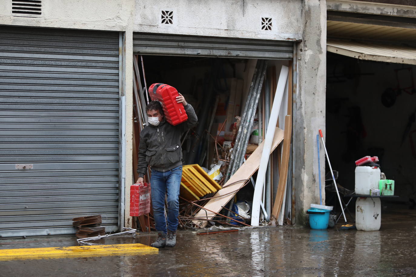 Propietarios limpian las lonjas afectadas por la subida del río en Basauri.