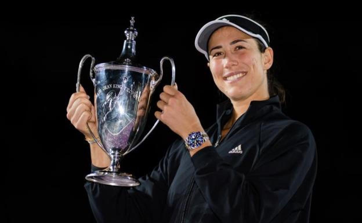 Muguruza posa sonriente con su título de maestra WTA. 