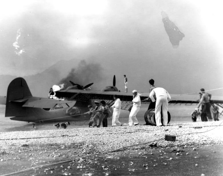 Los marineros intentan salvar un avión anfibio PBY en llamas durante la incursión japonesa en la Estación Aeronaval de Kaneohe Bay, cerca de Pearl Harbor. Armada de EE. UU. / Comando de Historia y Patrimonio Naval de EE. UU.