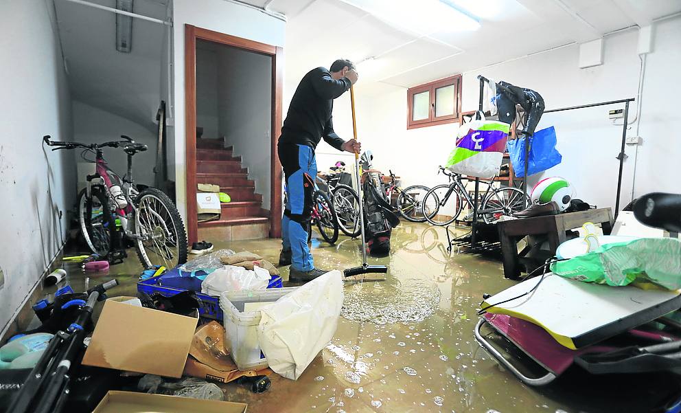 Secuelas. Un vecino de Muxika limpia su garaje, anegado por la riada. 