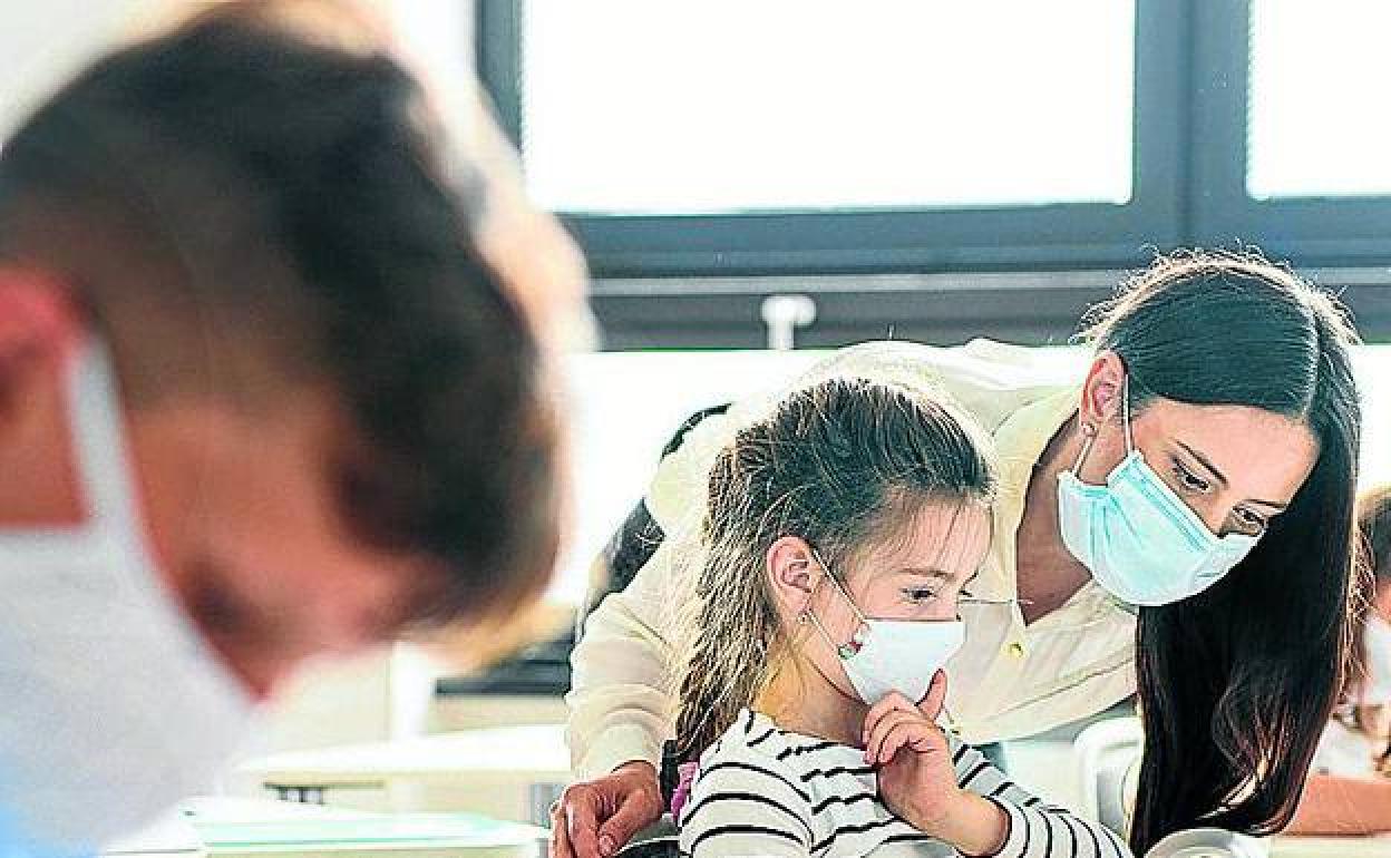 Un grupo de niños con mascarilla en la escuela. 