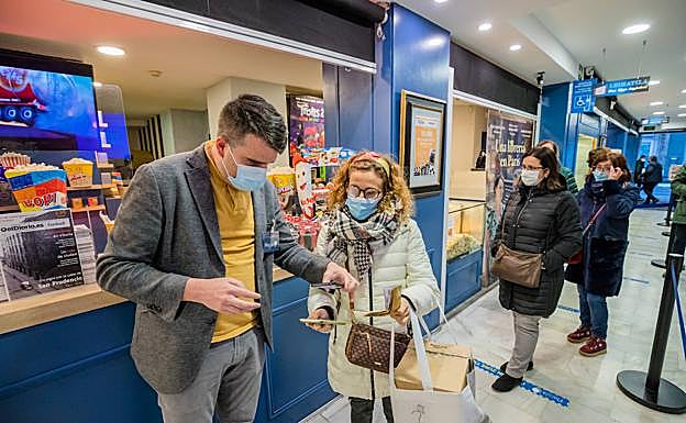 Esti López de Briñas enseña su certificado y su DNI a la entrada de los cines Florida. 