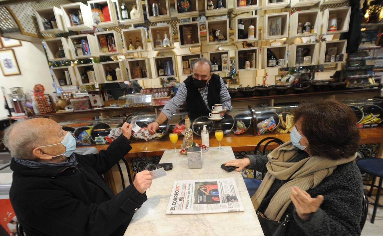 Un cliente muestra los pasaportes Covid a Javier, camarero del bar Calipso situado en la Avenida Gasteiz.