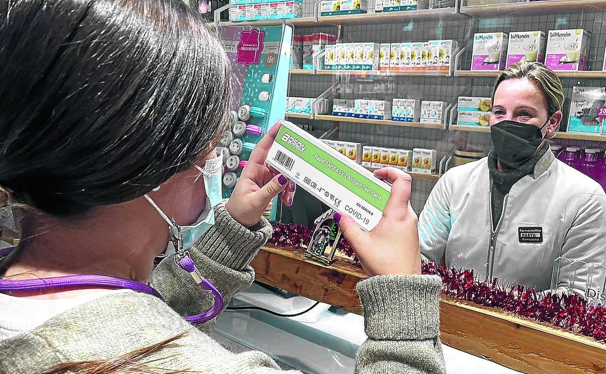 Una clienta compra un test de antígenos de producción china en una farmacia de Bilbao. 