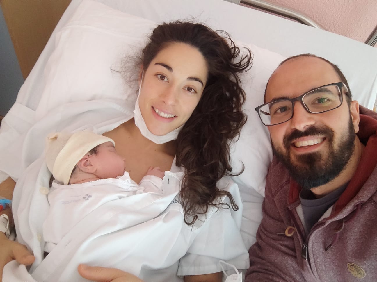 Marta y Adrián posan sonrientes con la pequeña Julia. 