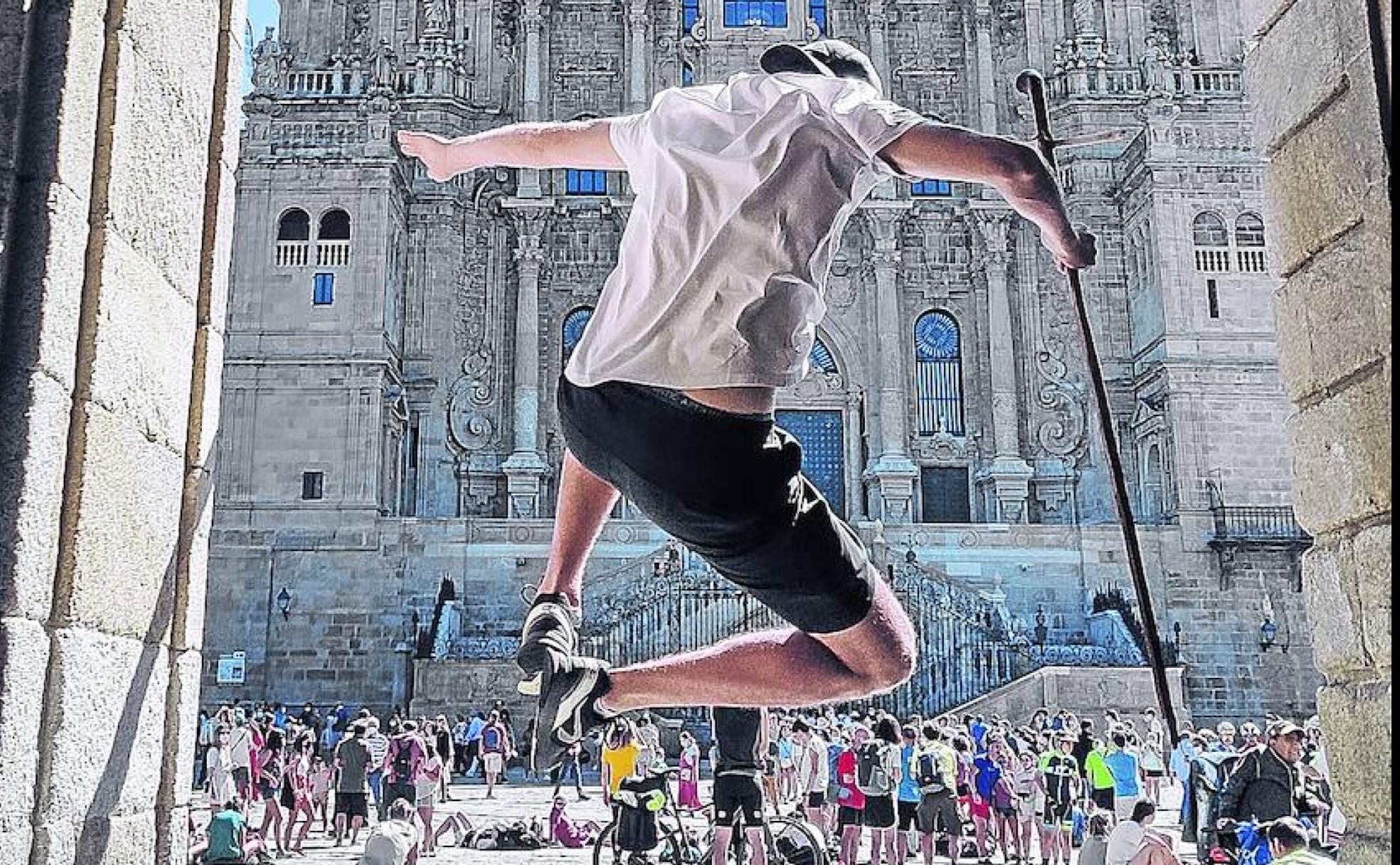 Un peregrino salta de júbilo tras llegar a la catedral de Santiago, recién restaurada.