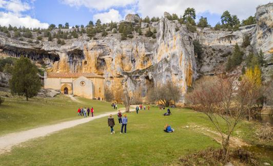 La ermita de San Bartolomé se alza al pie de los acantilados horadados por el río.