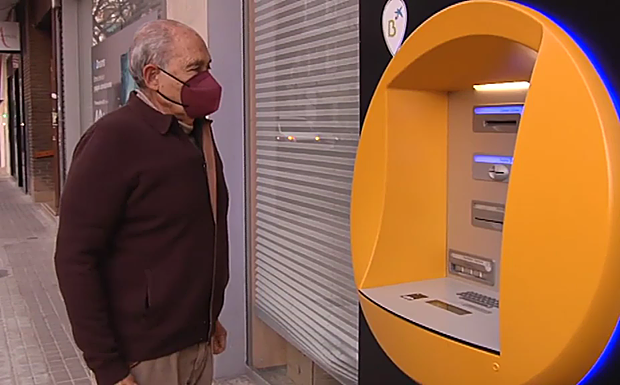 Carlos, ante un cajero automático. 