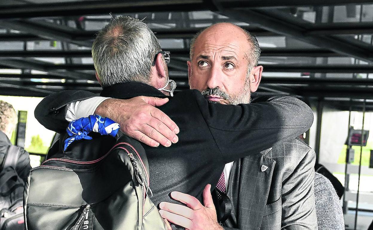 Aitor Elizegi se abraza ayer a su directivo Tomás Ondarra al despedirse tras llegar de Riad. 
