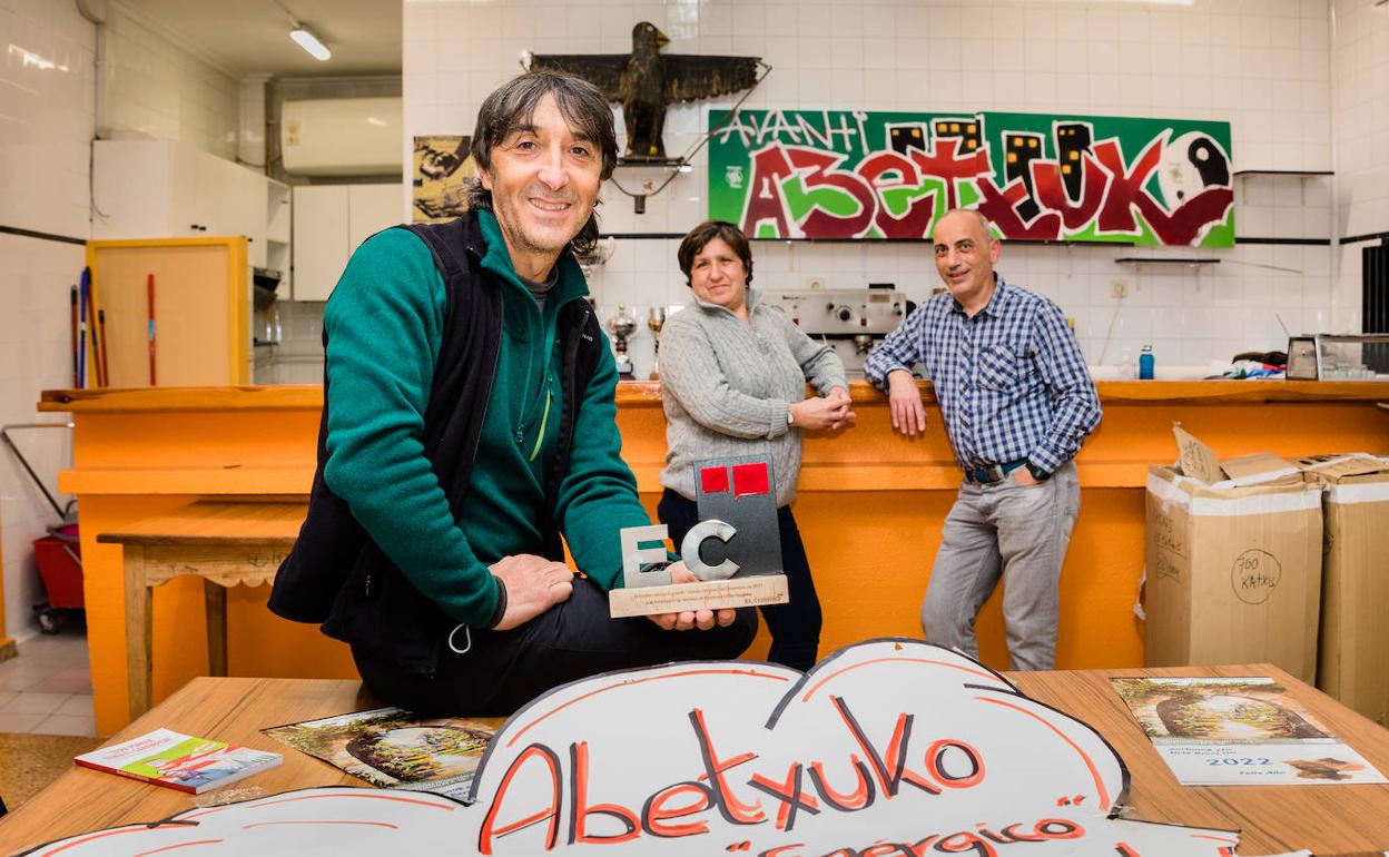 Oskar González, en primer plano, sostiene el premio de EL CORREO acompañado por Azucena y Javier, miembros de la asociación.