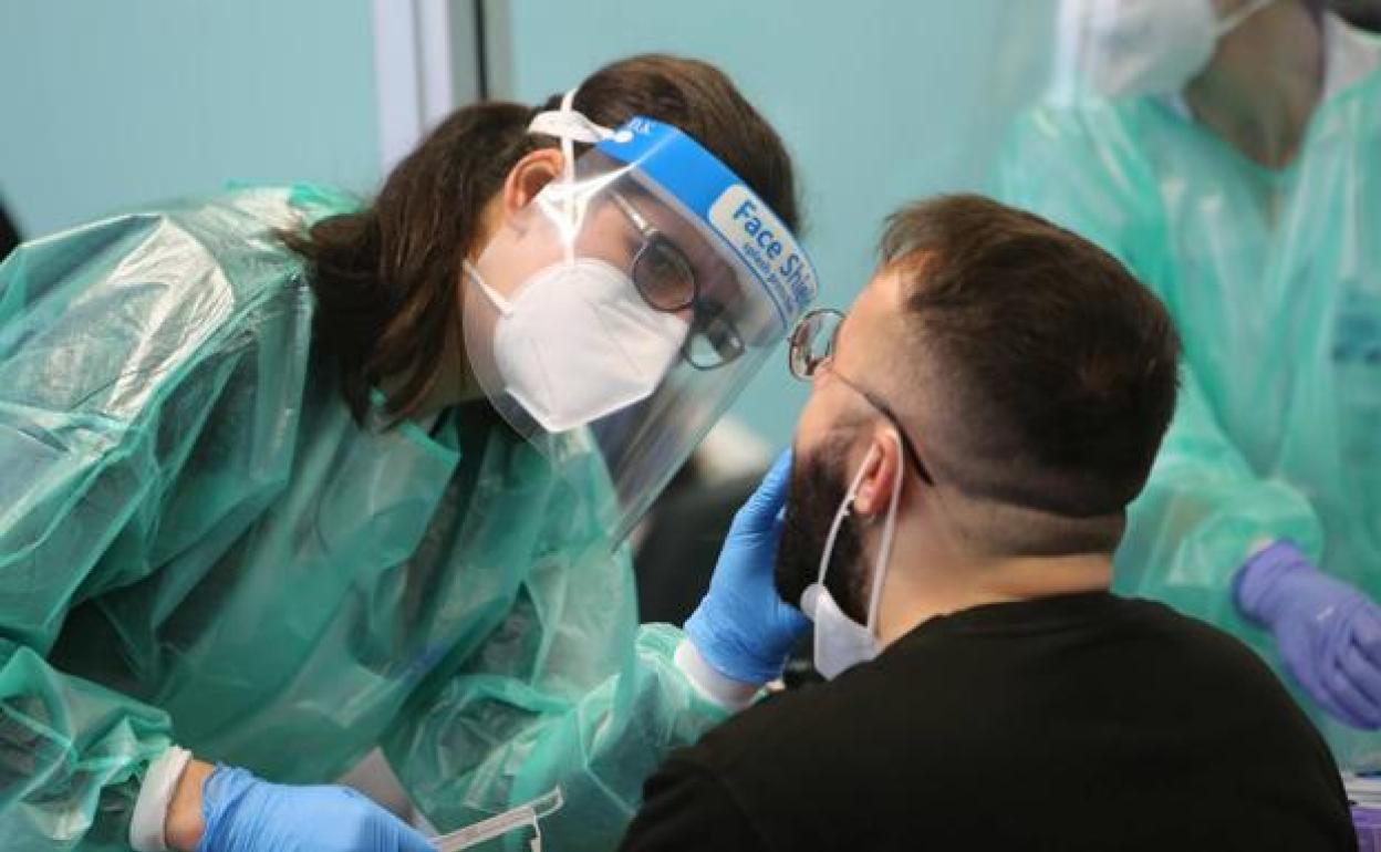 Una sanitaria realiza un test a un paciente. 