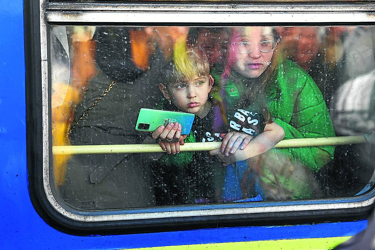 Una familia ucraniana emprende en tren el éxodo hacia la frontera con Polonia. 