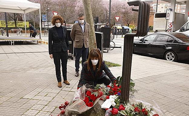 Idoia Mendia deposita un ramo de flores junto al monolito.