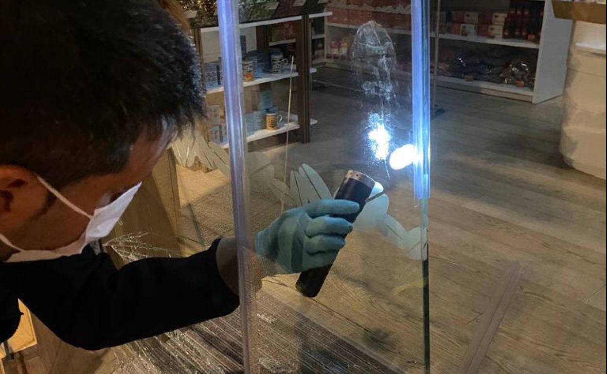 Un ertzaina observa la huella del zapato de un ladrón en un local de Vitoria. 