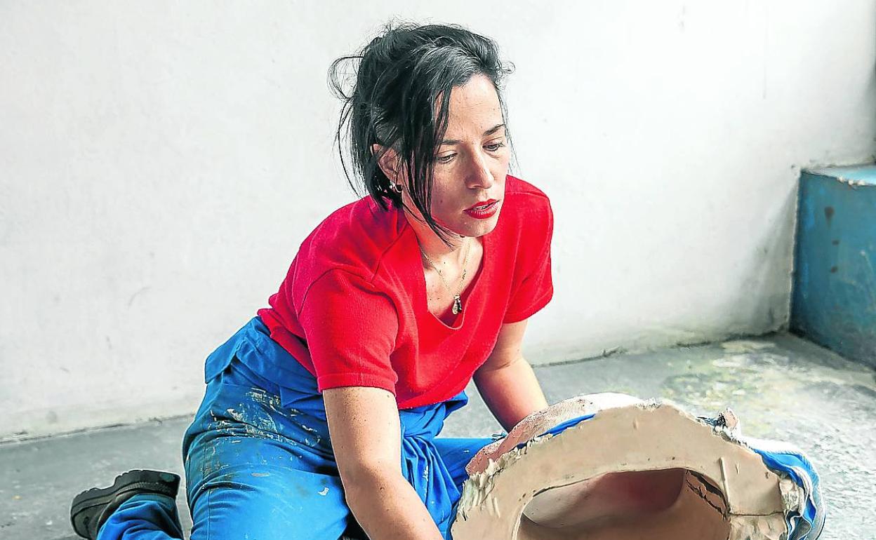 June Crespo trabaja en el estudio con una de sus obras. 